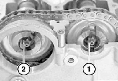 15. Ослабьте болт (1) на распределительном валу впускных клапанов, а затем полностью выверните болт…