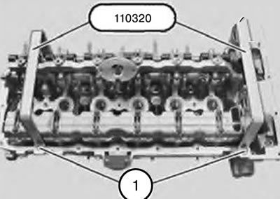 24. Закрепить приспособление 110320 имеющимися болтами (1) крепления крышки головки блока цилиндров.